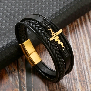 Detail of multi-layer black leather bracelet with golden heartbeat sign and magnetic clasp