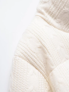 Close-up detail of white knitted cardigan showing premium chunky cable stitch texture
