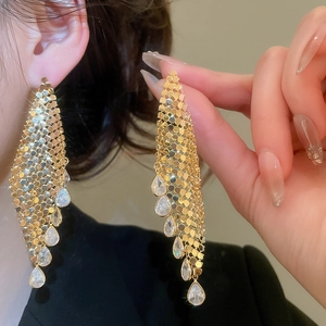 Detail of gold-plated mesh earrings with shimmering teardrop cubic zirconia tassels