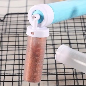 Manual cake airbrush with measuring bottle filled with red glitter for baking decoration