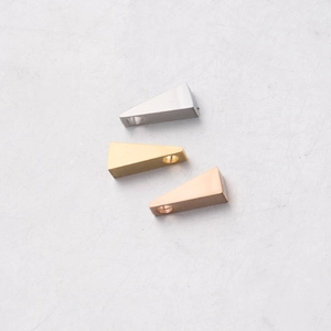 Detailed shot of triangle stainless steel pendants in silver, gold, and rose gold finishes