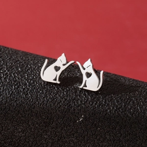 Close-up of silver cat-shaped stainless steel stud earrings with hollow heart details