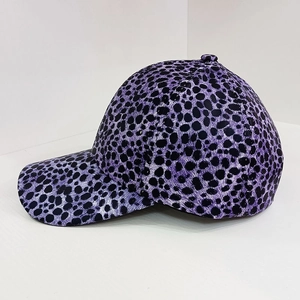Detail view of purple baseball cap featuring classic black leopard print patterns