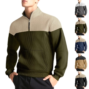 Detail of waffle knit fabric and color-blocked quarter-zip collar on men's pullover sweater