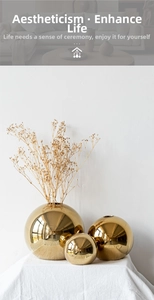Detailed view of three sizes of golden electroplated spherical ceramic vases for home decor