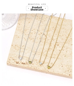 Minimalist gold and silver necklaces with zircon pendants on natural stone texture