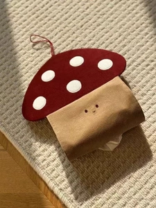 Macro detail of mushroom tissue holder with red polka dots and knitted smiley face
