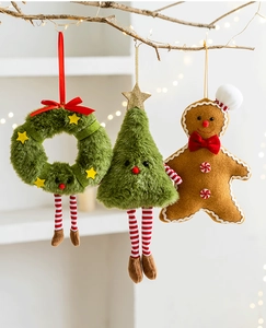 Detail of Christmas wreath, plush tree, and gingerbread man ornaments hanging on a branch