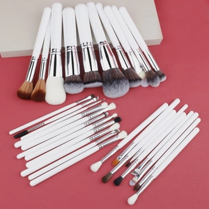 Detailed set of 30 professional makeup brushes with white handles on a red background