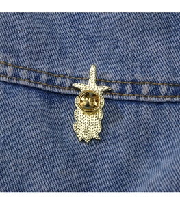 Close-up of golden metal pin back with butterfly clasp on blue denim fabric
