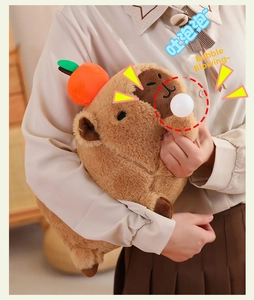 Detail of Capybara plush toy with orange decoration and interactive bubble feature