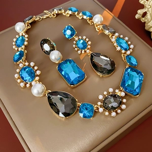 Detailed macro view of vintage jewelry set featuring blue gems and elegant pearls