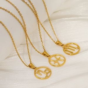 Gold hollow zodiac necklaces featuring Capricorn Pisces and Scorpio symbols on white fabric