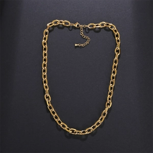 Detailed view of a chunky gold stainless steel chain necklace on a textured black surface
