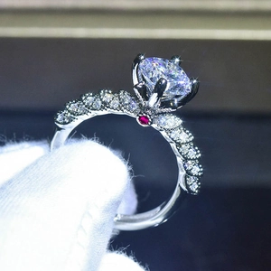 Dettaglio macro dell'anello d'argento a sei griffe con fascia a treccia e rubino alla base