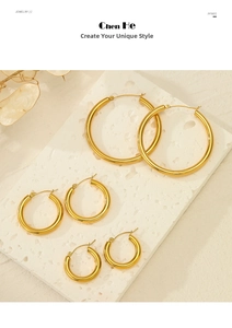 Detailed view of three pairs of gold hoop earrings in small to large sizes on a stone display