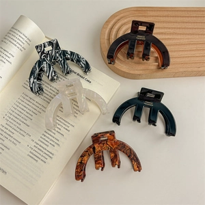 Elegant semi-circular acetate hair claws in various marble patterns for stylish women