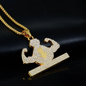 Detail of hip hop gold necklace with iced out muscular pendant and dollar sign symbol