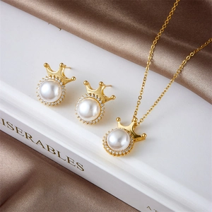 Elegant gold pearl crown necklace and earrings jewelry set on a satin background