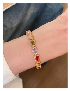 Close-up of elegant gold bracelet featuring colorful oval zircons and micro-pave detailing