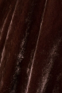 Macro di tessuto in velluto marrone scuro con texture morbida e dettagli plissettati