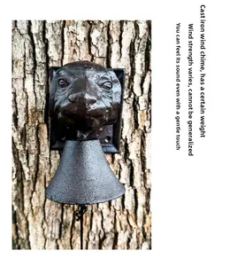 Detail of vintage cast iron dog head doorbell mounted on a rustic tree trunk outdoors