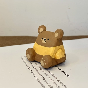 Détail d'une figurine d'ours en bois peint servant de support de stylo de bureau créatif