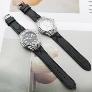 Detail of quartz watches showing leather straps with X-shaped stitching and rivet bezels