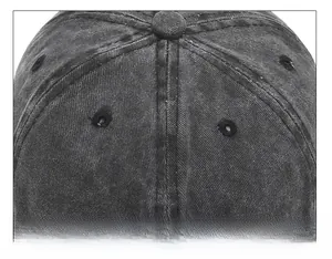 Detail of six-panel stitched crown and top button on washed dark grey cotton baseball cap