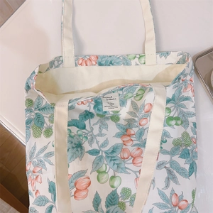 Detailed close-up of floral print patterns and fabric texture on a large canvas tote bag