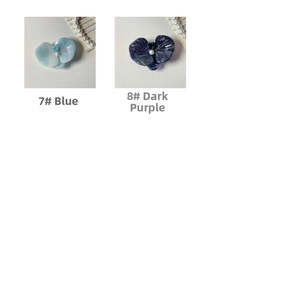 Detail of floral hair clips in blue and purple acetate with center pearl accents
