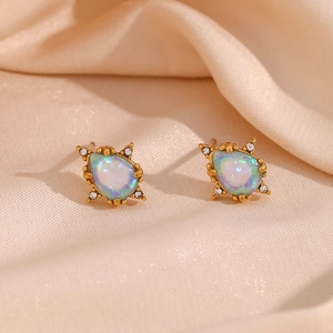 Close-up of vintage gold teardrop earrings with opal stones and zircon accents