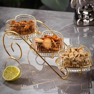 Gouden metalen rek met drie verdiepingen en hartvormige glazen schalen voor snacks