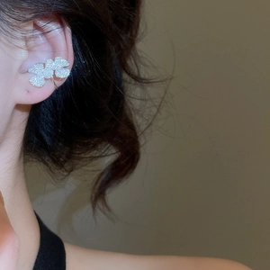 Detail view of silver cubic zirconia petal ear cuff worn on the cartilage area