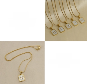 Close-up of square 18K gold snake chain necklace with natural shell alphabet pendant