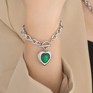 Detail of silver OT toggle clasp and heart-shaped green crystal pendant on link bracelet