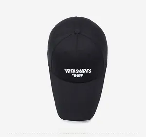 Top down view of black cotton baseball cap with white embroidered TREASURES 1987 logo
