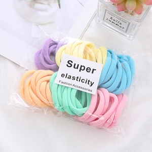 Close-up of macaron colored elastic seamless hair ties in branded transparent packaging