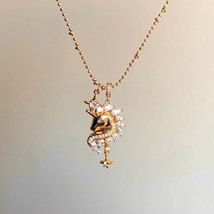 Macro detail of 18k gold plated unicorn necklace featuring sparkling cubic zirconia stones