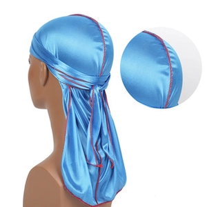Detail view of sky blue satin durag featuring contrasting red stitching and smooth texture