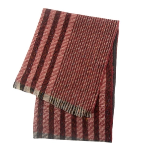 Detail of burgundy and beige striped knit scarf with tweed texture and fringe edges