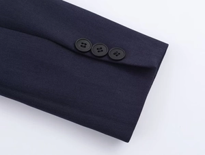 Detail of dark blue twill sleeve featuring three professional matte black buttons on cuff