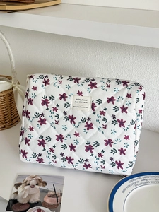 Quilted floral cosmetic bag in cream with purple flowers and zip closure for travel
