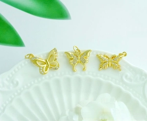 Detailed close-up of 18K gold plated butterfly charms with micro-pave cubic zirconia