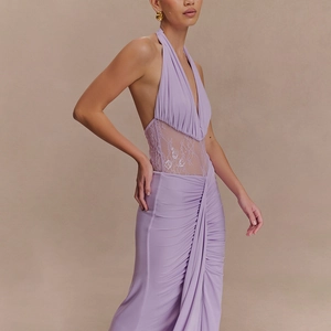 Détail de la robe longue dos nu violette avec découpes en dentelle et jupe plissée fluide