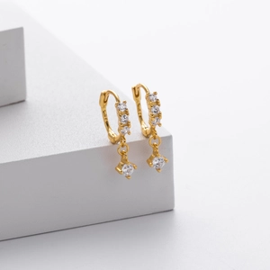 Gros plan de boucles d'oreilles en argent S925 doré avec zircon sur support blanc