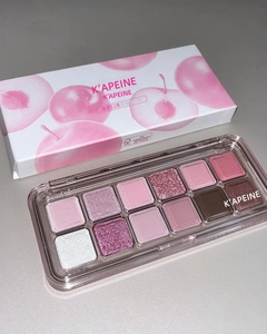 Detail shot of a 12-color eye shadow palette featuring pink and purple peach tones