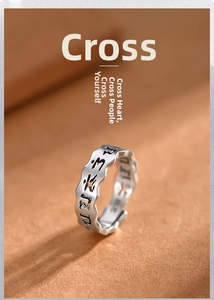 Macro shot of retro silver ring with carved Buddhist mantras and wavy edges