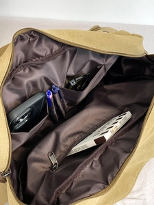Large khaki canvas messenger bag with organized interior compartments for travel and school