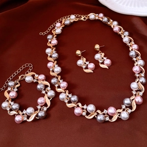 Flat lay of vintage gold jewelry set with pink and white pearls plus shiny rhinestones